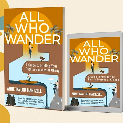 A book and a tablet titled “All Who Wander” by Anne Taylor Hartzell, showing a guide to finding your path in seas of change, on a winding desert trail.
