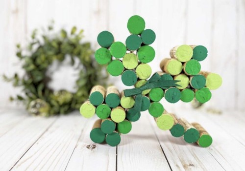 A colorful wooden star-shaped craft made of green circular pieces sits on a light wooden surface, with a decorative wreath in the blurred background.