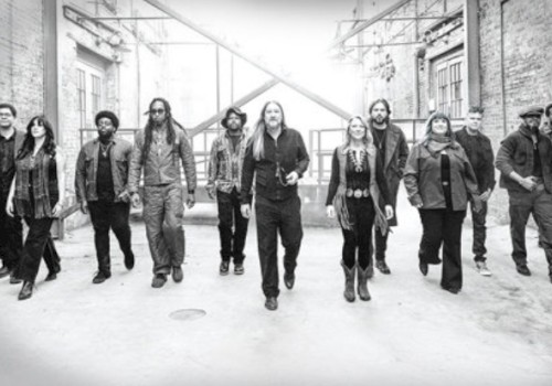 A diverse group of ten people walking confidently in an urban alley, suggesting unity and purpose in a candid black-and-white shot.