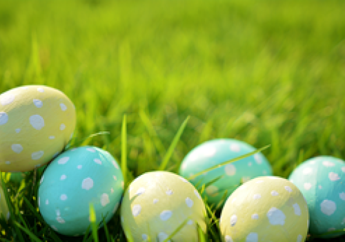 Colorful Easter eggs with polka dots placed on green grass, celebrating the festive spring occasion.