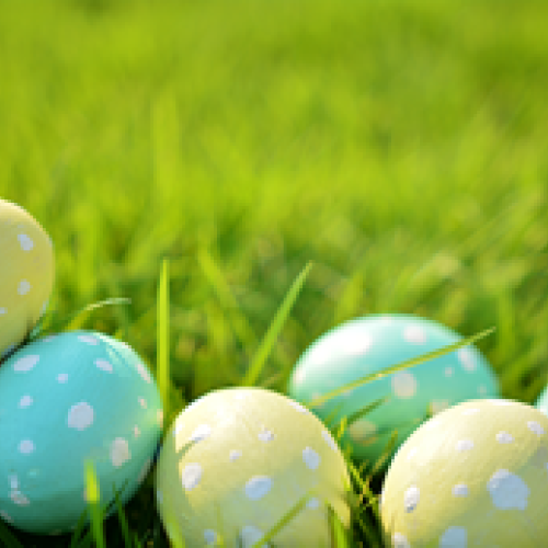 Colorful Easter eggs with polka dots placed on green grass, celebrating the festive spring occasion.
