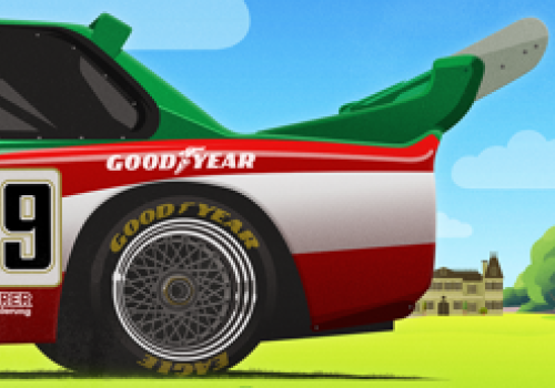 A racing car with a Goodyear tire, a green and black rear wing, and an open cockpit on a grassy background with trees and a house.