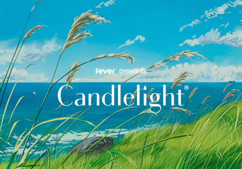 A scenic coastal landscape with green grass, tall reeds, blue ocean, and partly cloudy sky, advertising an event called Candlelight.