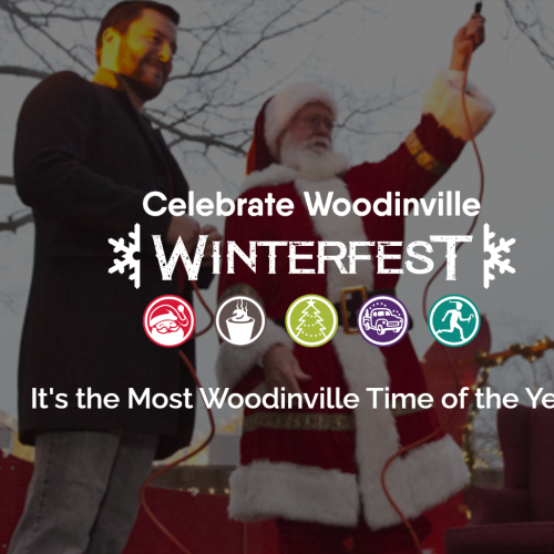A man dressed as Santa Claus and another person are on a stage at Winterfest in Woodville, celebrating the festive season with a crowd.