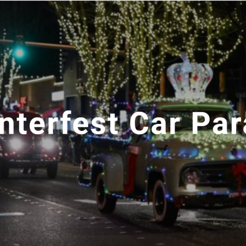 Colorful cars decorated with lights and a giant crown parade through a city street at night during the Winterfest Car Parade.