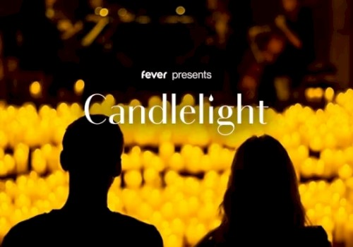 Silhouettes of two people sit facing many candles with text 